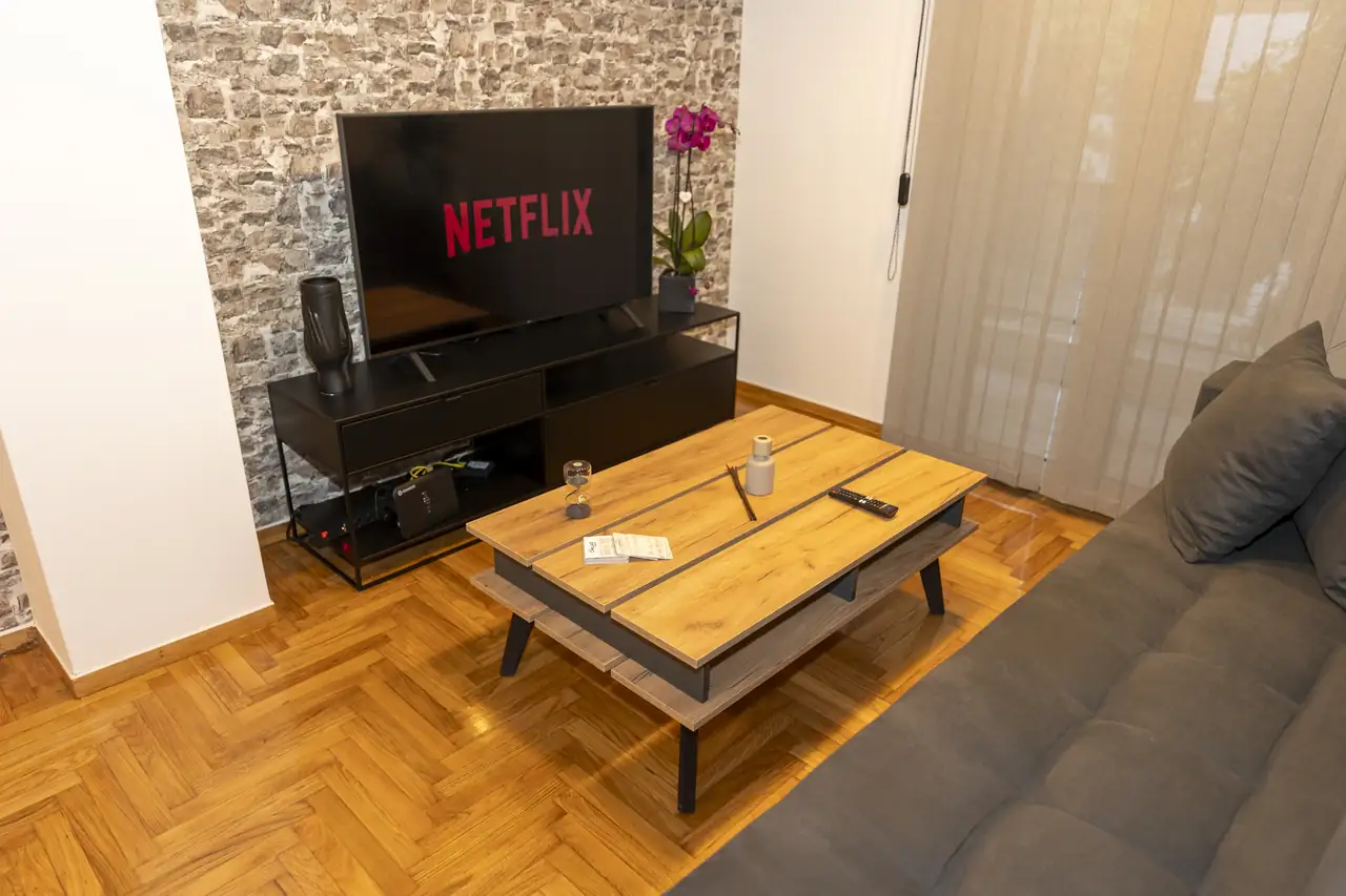 Lounge with exposed brick wall and TV